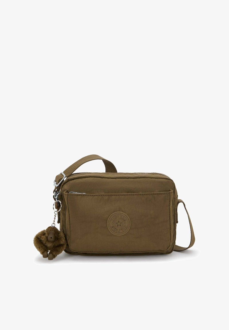 Brązowa prostokątna torba na ramię z przednią kieszenią na zamek, regulowanym paskiem, okrągłą naszywką z logo oraz małą pluszową breloczkiem w kształcie małpki.