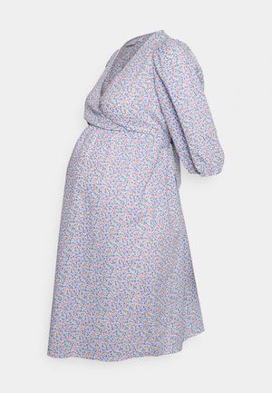 Vestido de maternidade floral em azul claro com pequenas flores multicoloridas. Apresenta um design envolvente, mangas bufantes e uma saia até ao joelho.