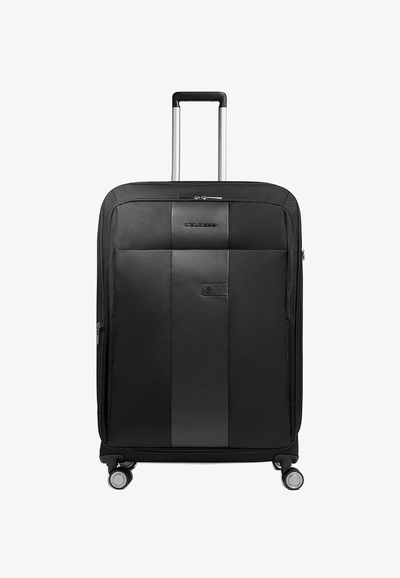 Maleta negra con exterior de tela texturizada y una franja de acento negra lisa. Cuenta con un asa telescópica y cuatro ruedas.