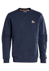 Marineblaues Sweatshirt aus weicher Baumwolle. Mit Rundhalsausschnitt, gerippten Bündchen und einem kleinen gelben Schuhlogo auf der Brust. Glatte Textur.