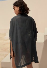 Transparenter, dunkelgrauer Kimono-Style Überwurf mit lässiger Passform, der subtile horizontale Streifen und kurze Ärmel aufweist.