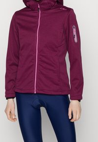 Dunkelroter Reißverschluss-Jacke mit Kapuze, ausgestattet mit einem pinkfarbenen Reißverschluss, Seitentaschen und einer Reißverschlusstasche am Arm. Glatte Textur und körperbetontes Design.