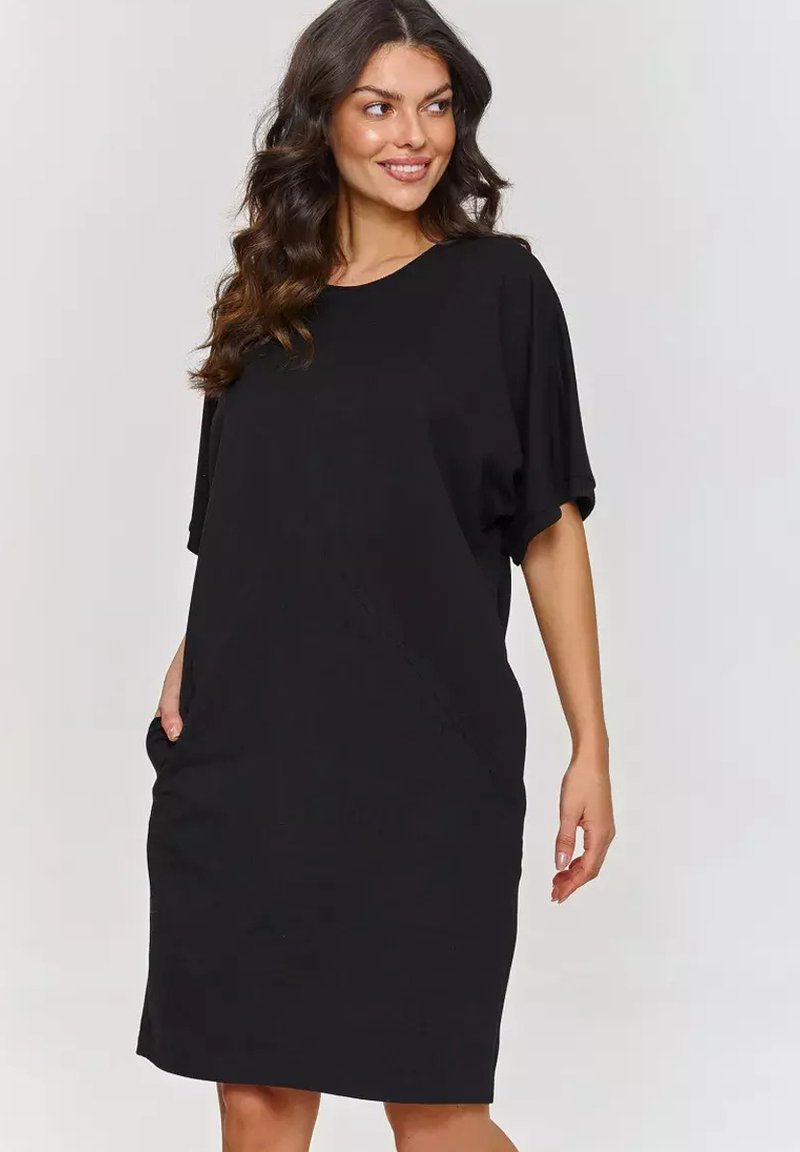 Czarna sukienka z krótkimi rękawami i luźnym krojem, wyposażona w boczne kieszenie, wykonana z miękkiego materiału, z okrągłym dekoltem i długością do kolan.