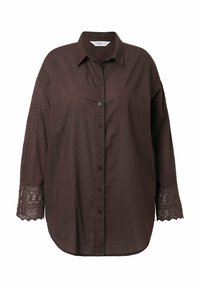 Camisa marrón abotonada con mangas largas que presenta detalles de encaje bordado en los puños. Hecha de tela ligera, con un ajuste ligeramente holgado.