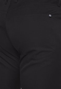 Schwarze Baumwollmischungshose mit einer Gesäßtasche und kleinem Logo. Der Stoff hat eine glatte, matte Textur und ein gerades Bein-Design.