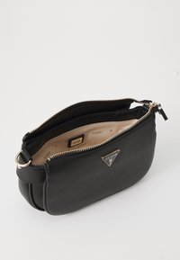 Borsa a tracolla nera in finta pelle con forma arrotondata, zip dorata e dettaglio del logo. L'interno presenta una fodera beige con etichetta del marchio.