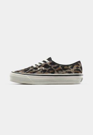 Leopardenmuster Canvas Sneakers mit weißen Schnürsenkeln, flacher Sohle und schwarzem Rand. Branding an der Seite mit strukturierter Oberfläche.