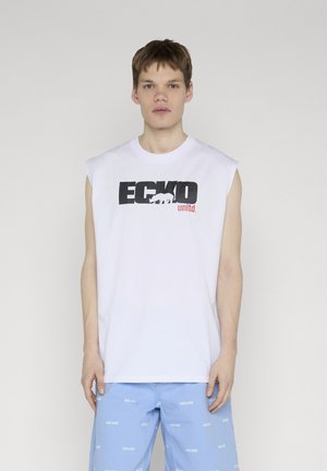Jeune homme portant un débardeur blanc ECKO unltd. et un short bleu clair avec de petits logos blancs répétés ECKO unltd.