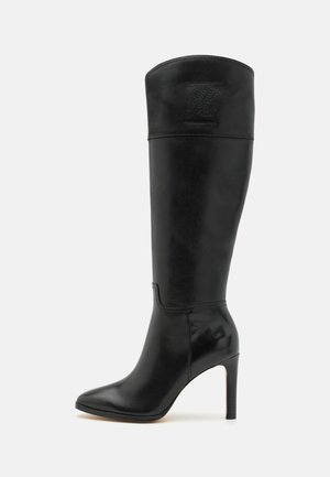 Botte en cuir noire montant jusqu'aux genoux avec un talon stiletto haut, un bout pointu, et un logo de marque subtilement embossé près du haut de la tige.