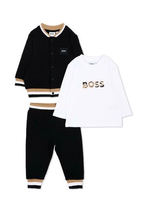Chaqueta negra de niño con botones, pantalones a juego con ribetes en color tostado y blanco, y camisa blanca de manga larga con el logo BOSS en letras tostadas y negras.