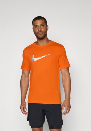 Oranje t-shirt van katoen, met een blauw-wit Nike-logo op de borst. Korte mouwen en klassieke ronde halslijn.