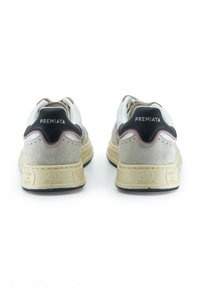 Weiße und graue Wildledersneaker mit einer schwarzen Fersenlasche, pinken Akzenten und einer strukturierten Oberseite. Sie verfügen über eine dicke beige Gummisohle mit Branding.
