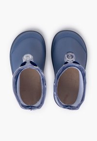 Sandali in silicone blu con punta arrotondata, soletta texture e cinturino regolabile con una fibbia tonda trasparente.