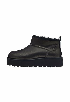 Bottines noires avec une surface brillante et texturée, des accents en textile et une semelle surélevée. Possède un tige courte et une languette à l'arrière.