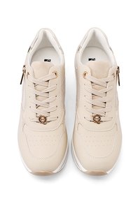 Sneaker beige con una toma superiore in materiale sintetico liscio, chiusura con lacci, area della punta perforata e un accento dorato sui lacci. Suola bianca.