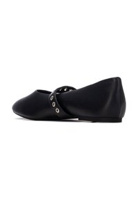 Zapatos planos negros con textura suave de cuero, punta estrecha y una correa con detalles de ojetes plateados que se envuelve alrededor del mediopié.