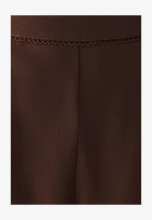 Tejido marrón con un acabado suave y texturizado. Presenta un borde festoneado en la cintura, enfatizando las líneas limpias y una apariencia ajustada.