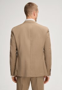 Beige Anzugjacke mit strukturierter Oberfläche und vertikalen Streifen. Verfügt über ein Revers und geknöpfte Manschetten. Standardpassform und mittellang.