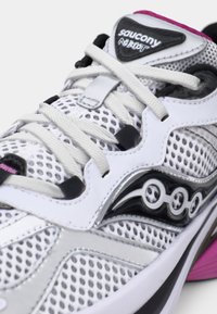 Balti sportiniai bateliai iš tinklinio audinio su sidabro ir juodos spalvos akcentais, pilka pada, rožiniais elementais ir firminiu liežuviu.