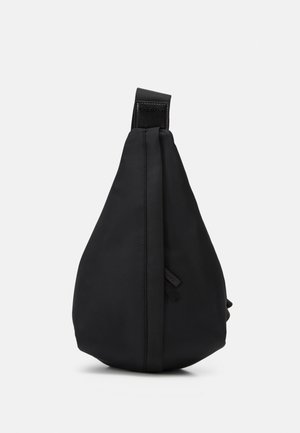 Sac bandoulière en nylon noir de forme triangulaire, doté d'une sangle supérieure et d'un design minimaliste. Texture lisse avec des détails de marque subtils.