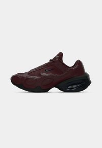 Bordo Nike superge z teksturiranim zgornjim delom, izrazitim blaženjem, črnimi detajli in zaobljenim podplatom. Ima majhen logo na strani.
