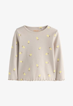 Beżowa koszula z długim rękawem w żółte wzory liści, o prążkowanej fakturze, z falbankowym dołem i okrągłym dekoltem. Na kołnierzu widoczna metka marki "NEXT".
