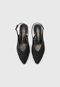 Fekete slingback magassarkú cipők hegyes orral, texturált anyagból, fonott mintázattal. Karcsú bokapánttal rendelkezik.