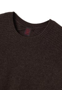 Maglione lavorato a maglia marrone con scollatura a girocollo a coste e maniche raglan. L'etichetta presenta testo rosso su sfondo nero. Texture morbida.