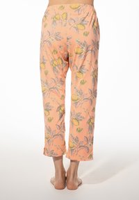 Lichte, perzikkleurige pyjamabroek met een citroen- en bladvormig patroon. Heeft een elastische tailleband en een cropped lengte. Zachte katoentextuur.