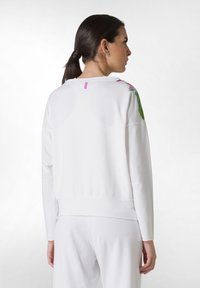 Witte katoenen sweatshirt met lange mouwen, ribbelmanchetten en een ronde hals; voorzien van kleurrijke bloemaccenten op de schouders en een klein logo-label.