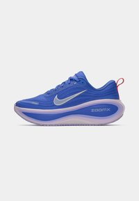Μπλε Nike ZoomX αθλητικό παπούτσι με υφασμάτινη εξωτερική επιφάνεια, λευκό λογότυπο swoosh, επενδεδυμένο μωβ μεσαίο σόλα και κόκκινη λεπτομέρεια στη φτέρνα.