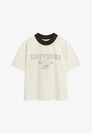 T-shirt couleur crème à manches courtes, col côtelé marron, et texte brodé 'UNIVERSE' avec un graphique de planète en dessous.