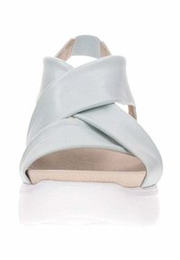Sandalias de cuero sintético azul claro con tiras entrelazadas, parte trasera abierta, plantilla acolchada y suela de goma blanca.