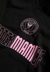 Felpa nera con logo circolare rosa e testo in grassetto "INTERMIAMICF" di colore rosa sul davanti, realizzata in tessuto testurizzato.