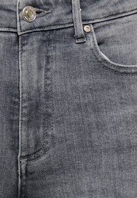 Donkergrijze denim jeans met een zak aan de voorkant, een metalen knoopsluiting en zichtbare stikdetails langs de naden.