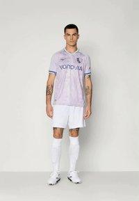 Svijetloljubičasta nogometna majica s plavim naglascima, koja sadrži logo "VONOVIA", uparen s bijelim hlačama, nošena s bijelim čarapama i kopačkama.