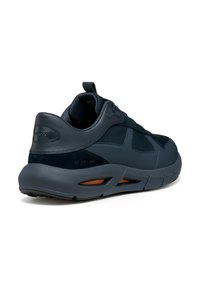 Zapatillas de deporte en azul marino con upper de cuero y ante, puntera redonda, cierre de cordones, suela gruesa y acentos naranjas en los laterales.