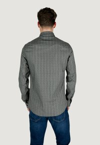 Camicia da uomo in tessuto a fantasia grigio e nero, con maniche lunghe, colletto classico e design aderente.