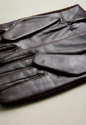 Pruunist nahast kindad, millel on sile tekstuur, viis sõrme, elastne randmeosa ning dekoratiivne õmblus servas.