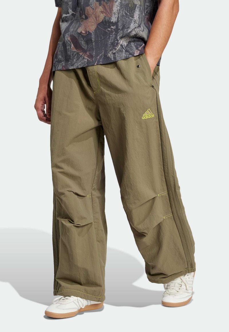 Khaki cargo pants with a lightweight material, featuring a relaxed fit, side pockets, and neon green accents, paired with white sneakers.