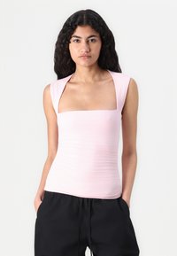 Top ajustado rosa con escote cuadrado amplio y mangas cortas. La tela tiene una textura suave con un ligero fruncido a lo largo de los lados.