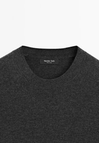 Tmavě šedý svetr s kulatým výstřihem. Měkká, pletená struktura. Obsahuje černý štítek s nápisem "Massimo Dutti" a "Vyrobeno v Číně".