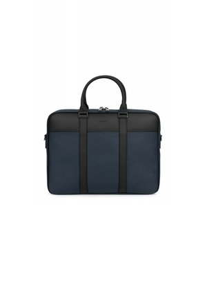 Navy blue leather bag with black accents, featuring two handles, zip closure, and a textured finish. Minimalist design with vertical straps.