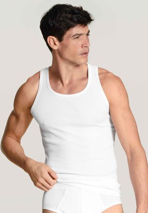 Witte geribde tanktop op een mannelijke model, met een ronde hals en een slim fit. Het materiaal lijkt zacht met een gladde textuur.