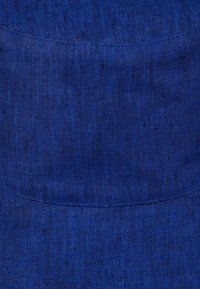 Tissu en lin bleu avec une finition texturée, présentant une surface lisse et des variations de teinte subtiles, idéal pour des chapeaux structurés ou des accessoires.