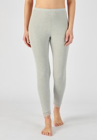 Lichtgrijze legging gemaakt van zachte stof, met een getailleerd ontwerp en een decoratieve kantafwerking bij de enkels. Soepele textuur, enkel-lang.