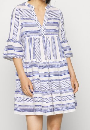 Biała sukienka z niebieskimi geometrycznymi wzorami, dekoltem w serek i trzyczęściowymi falbanowymi rękawami. Luźny krój w kształcie litery A, z poziomymi paskami.