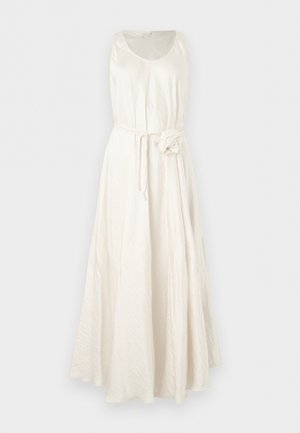 Mouwloze witte maxi-jurk met ronde halslijn, getailleerde taille en detail van een stoffen bloemenriem, weergegeven op een effen achtergrond.