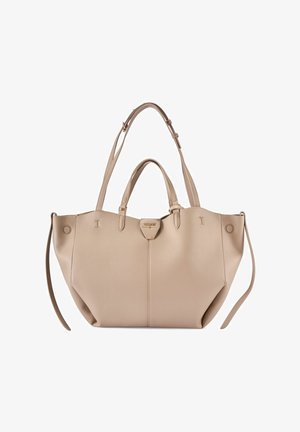 Beżowa skórzana torba typu tote z podwójnymi górnymi uchwytami, regulowanym paskiem na ramię i złotą tabliczką z logo umieszczoną na środku pod falistym brzegiem.