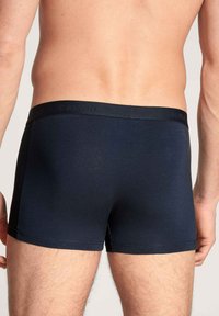 Boxer-briefs bleu marine fabriqués en tissu doux et extensible. Dotés d'un design ajusté avec une ceinture lisse arborant le logo de la marque.